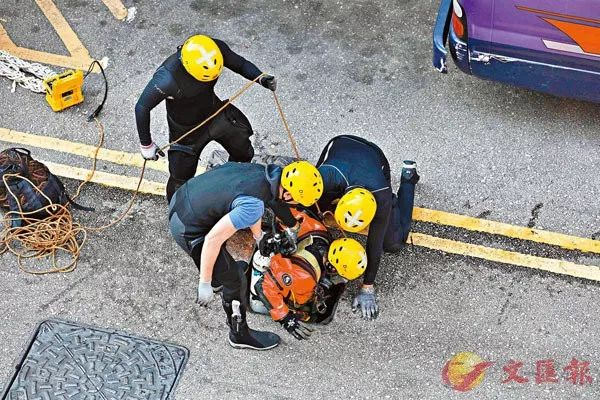  消防派员穿上防护衣在理大附近进入下水道，搜索有没有人受困。香港文汇报记者 摄