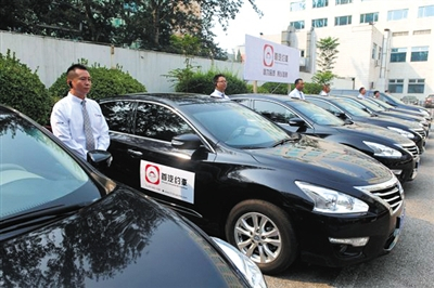 昨日，“首汽约车”首批500辆车正式运营。司机通过手机APP接受乘客的订单。