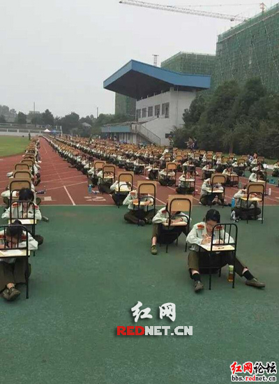 （湖南农业大学新生军训席地而坐接受军事理论考试）