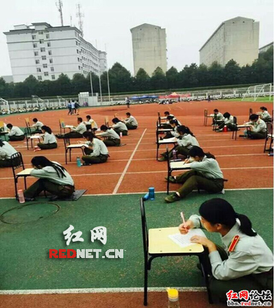 （新生坐在学校塑胶跑道上参与大学里的第一次考试）