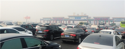 　　昨日下午2时许，京港澳高速公路进京方向河北界路段，等待通过收费站的车辆排成长队。新京报记者 贾世煜 摄