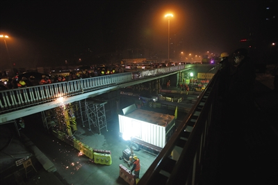 昨晚，三元桥（跨京顺路）旧桥梁正在被分块切割，将由驮梁车运走。 新京报记者 王贵彬 摄