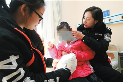 女孩在救助机构，民警看望并陪其玩耍。大兴警方供图