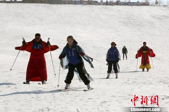 图为民众身着传统服饰参与滑雪运动