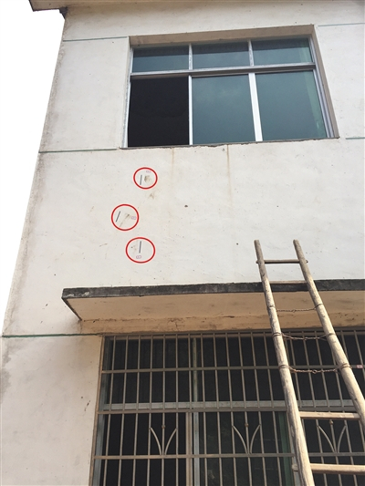 在凶案发生的房子外侧，警方至少标记11处符号（红圈处）。新京报记者 罗婷 摄