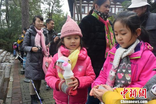 一名女童用纸杯制作“冰淇淋娃娃”。 蒋雪林 摄