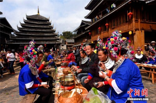　　2月10日正月初三，广西三江侗族自治县程阳八寨景区举办猴年春节首场侗族特色风情活动。图为游客体验百家宴。 龚普康 摄