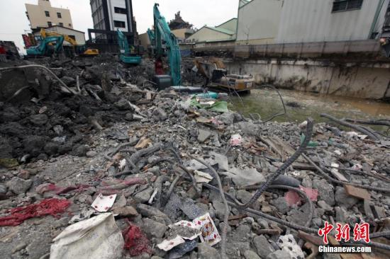 　　2月16日，在6日发生的高雄地震中倒塌的台南维冠大楼现场，附近道路交通已恢复，大型机械持续清理原大楼地基。 中新社记者 刘舒凌 摄