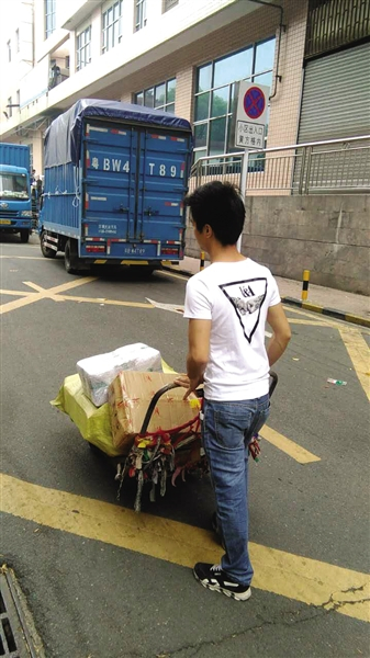 昨日，深圳东门迎宾馆停车场旁。因为车被扣，面包车进不了小巷子，只能拖运送货。读者供图