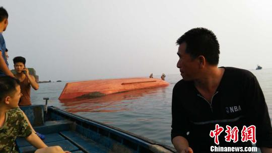 图为翻扣在海面上的渔船。 郭兴朝 摄