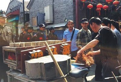 综合执法人员暂扣了一家湘菜馆的经营工具，拆除了店铺招牌以及广告灯箱。新京报记者 郭超 摄