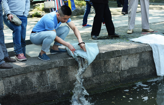 　　4月30日，浙江省杭州市，游客在杭州西湖岸边进行放生。在今年“五一”小长假期间，有游客趁杭州西湖管理部门管理空隙，偷偷在西湖水域放生，虽然有路过的市民和游客进行劝阻：“这样会破坏西湖原有的生态平衡”，但特地前来放生的游客还是从容将市场上买来的养殖鱼类投入西湖。 视觉中国供图