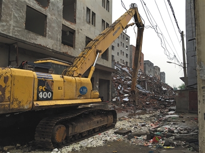 5月14日，一辆挖掘机在薛岗村拆迁工地，四周都是村民违建盖的楼房。