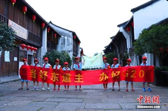 　　8月10日，一群小志愿者在浙江杭州小河直街合影留念。杭州小河直街历史文化街区地处京杭大运河、小河、余杭塘河三河交汇处。G20杭州峰会召开在即，小河直街也来了一次华丽“变身”成为花园街。 中新社记者 章天启 摄