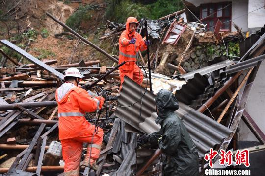 消防救援人员利用生命探测仪探测废墟下面是否有生命迹象。 李彬 摄