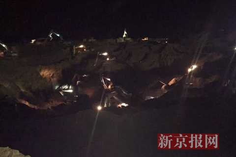 ▲8日凌晨，救援现场挖掘机仍在作业。新京报记者 摄