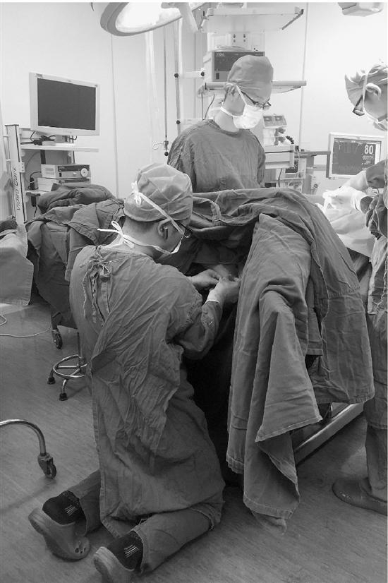  图：李杭正跪在地上做手术。