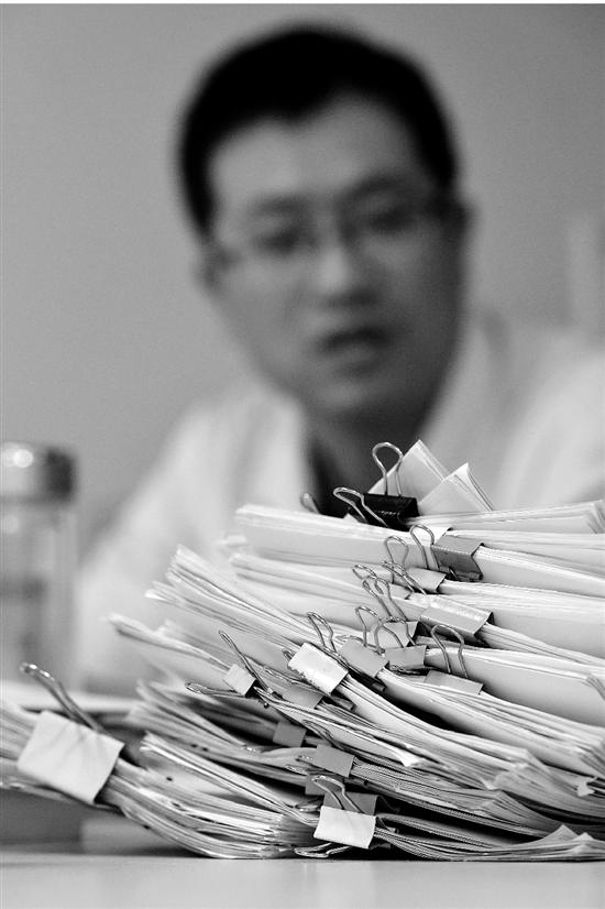 图：李杭的办公桌上堆满了病人的材料。