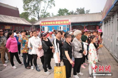  资料图：2014年5月1日，游客在故宫临时厕所外排长队。张一正 摄