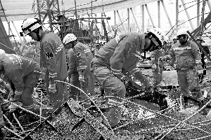 11月24日，救援人员在事故现场进行搜救。新华社发