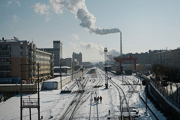 鸡西鸡冠区，铁轨穿过城区，远处是煤电厂。摄影：孙俊彬。