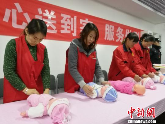 　　24日傍晚，山西省太原市，吕梁市委书记李正印吟诵两首自己写的顺口溜，向家政公司致谢，并推销吕梁山护工。图为护工练习护理婴儿。　李娜　摄