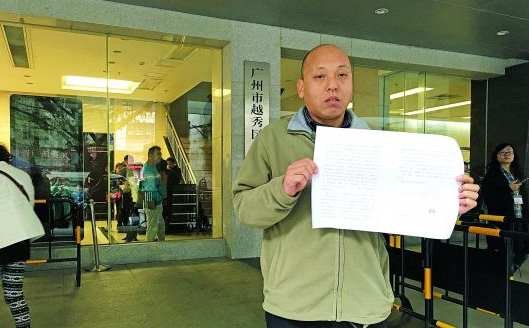 手持不起诉裁定书的王国其（图来自网络）