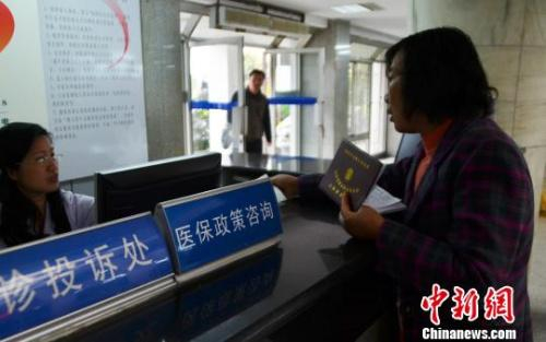 资料图：一名女子在医保政策咨询台前咨询。王思哲 摄。
