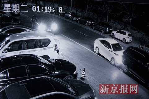 奥迪车突然猛向后退，撞击白色车辆前部，随后从左侧及前方两车夹缝中开出，并撞到站立在左前方的男子，向南逃跑。视频翻拍。新京报记者 李强 摄