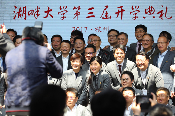 马云在湖畔大学与学员合影。