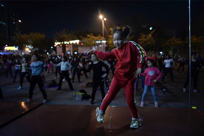每天晚上7点3半，在沙坪坝区金阳易城国际广场，小静静站在木台子上给上百人领舞。