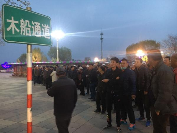 4月4日晚7时许，白洋淀码头附近，船工们聚集等待领取当天报酬。本文图片 澎湃新闻记者&nbsp;陈寞