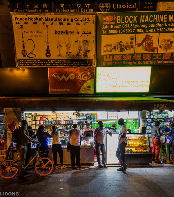 宝汉直街一景，非洲人选购手机和电话卡。李东 图