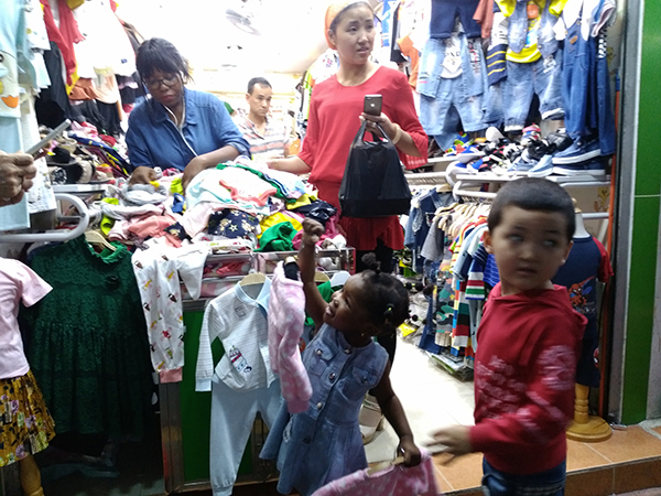 4月9日晚，宝汉直街，一个非洲女孩与一个新疆男孩在店里偶遇，并愉快地为对方试起了衣服。