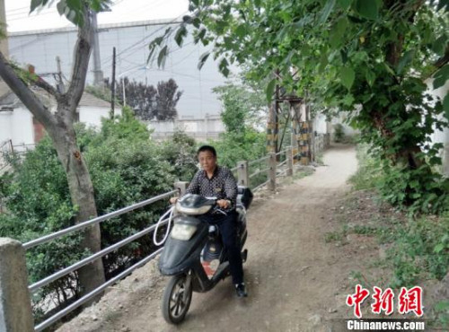 小区东门外居民骑车只能走这条坑洼小道。　朱志庚 摄