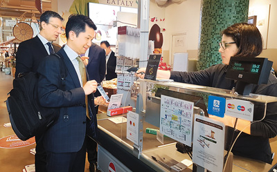 4月7日，在意大利罗马的Eataly美食超市，一名顾客使用支付宝结账。（新华社发）