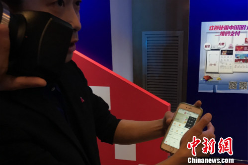 一位工作人员正在教体验者使用银联云闪付产品。中新网 种卿 摄