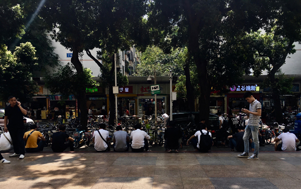 通天地通讯城前，坐着一排前来批发翻新手机的“背包客”。澎湃新闻记者 蒋晨悦 图