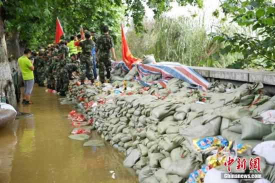 　　7月2日，截至当日15时，湘江长沙站涨致39.44米，超警戒水位3.44米，刷新了1998年39.18米的历史最高水位记录。图为军民合力在湘江路风光带抢筑防洪堤。中新社记者 杨华峰 摄