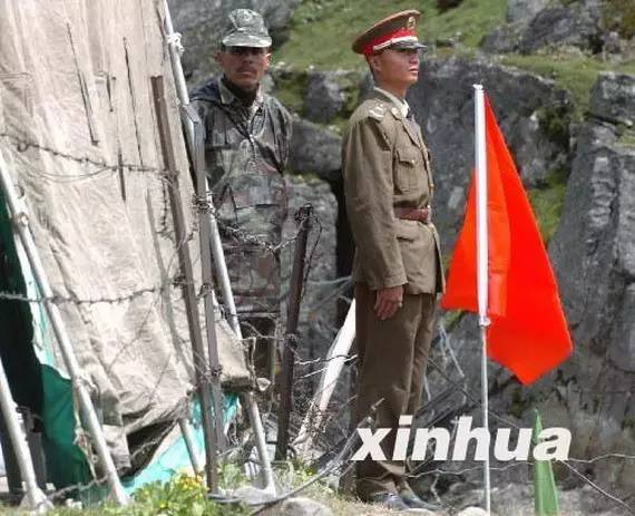 资料图： 2006年7月5日，在中印边境乃堆拉山口，一名中国边防军人（右）与一名印度边防军人隔着边界的铁丝网值勤。新华社记者 韩传号 摄