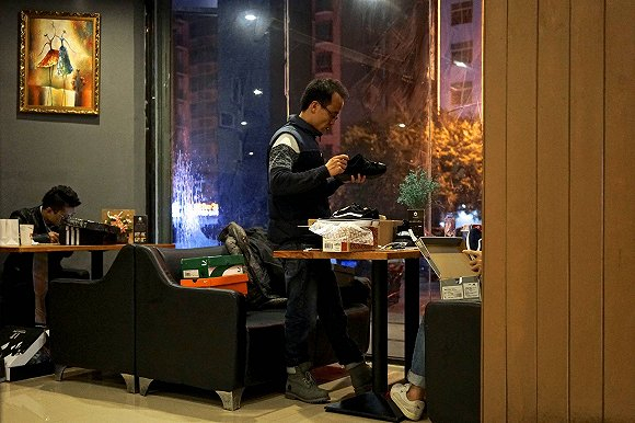 商贩正在修改鞋面标签，以便于假鞋看起来更逼真