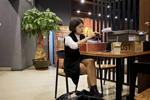 商贩正在修改鞋面标签，以便于假鞋看起来更逼真