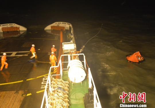 “东海救111”轮上的救助人员向遇险船员抛投救生索。　黄智明　摄