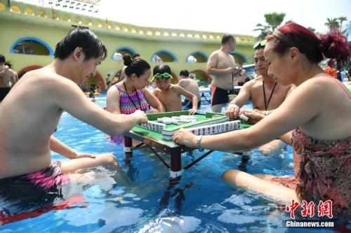 　　资料图：2017年8月2日，重庆洋人街一水上乐园举行夏季消暑活动，其中水中玩麻将吸引不少游客参与。陈超 摄