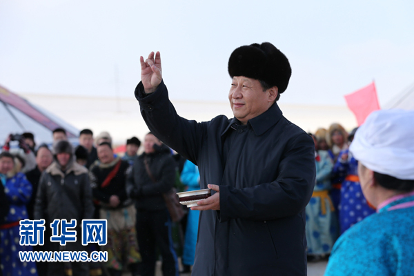 2014年1月27日，在锡林浩特市宝力根苏木（乡）冬季那达慕“五畜祈福”仪式上，习近平按照蒙古族习俗，用无名指蘸上银碗盛着的鲜牛奶弹了三下，祝福来年风调雨顺，五畜兴旺，人民幸福安康。新华社记者 庞兴雷 摄