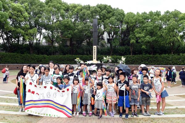  8月9日，日本长崎市在长崎和平公园举行原子弹爆炸72周年纪念仪式，人们在日本长崎原子弹爆炸遗址合影。新华社记者马平摄