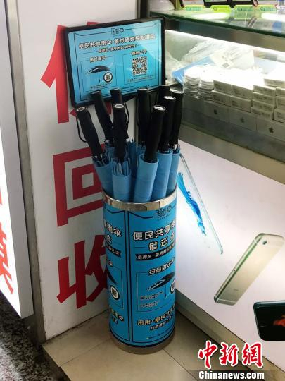 徐家汇地铁站一商户门口的共享雨伞借还点。　王子涛 摄