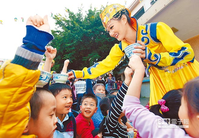 “蒙藏委员会”举行的校园推广活动，舞者让小学生体验顶碗功夫。（图片来源：台湾《中时电子报》）