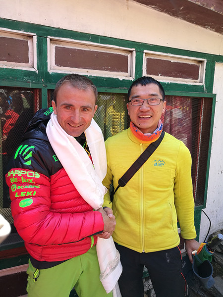 4月11日，罗彪（右）在寺庙祈福时偶遇乌里·斯特克，与之握手合影。