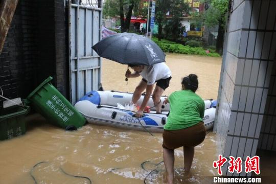8月15日，柳州市滨江西路1栋居民轮流守候充气船接送进出邻居。　林馨 摄